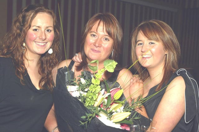 Rosemary and Lizzie Black present their mum Teresa Black with flowers to mark all her work in the club at the Glens YFC dinner in the Marine Hotel in Ballycastle in 2007