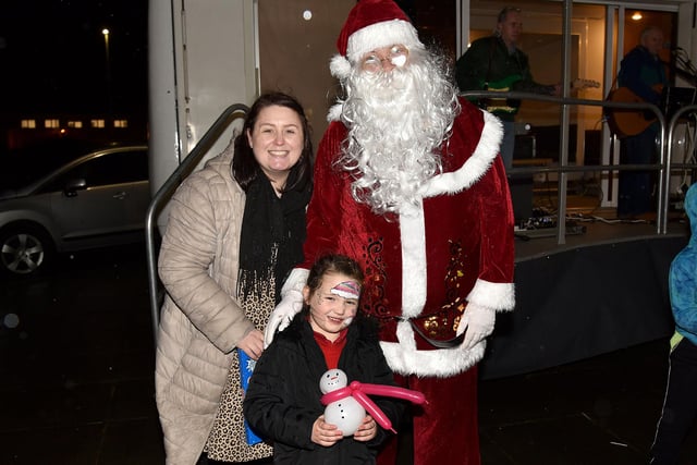 All smiles with Santa at the Christmas lights switch on at the Mayfair Business Centre, Garvaghy Road, are Claire Murphy and Evi Hughes (6). PT50-260.