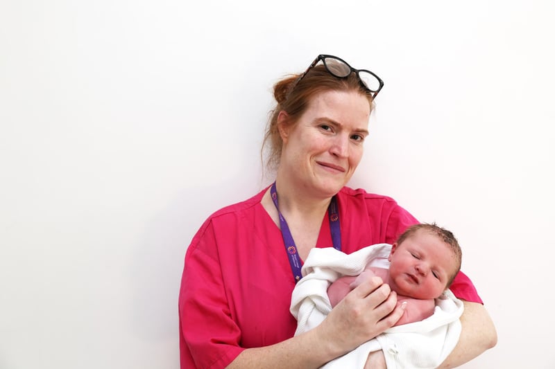 Midwife Kiara McElroy with Jude Reid from Lisburn who was born at 9.53am on January 1, weighing 9lb 9oz.