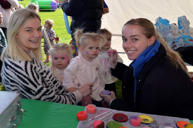 Cora Lyons (1) has her face painted by Anna Sharpe from 'Friendly Faces' as mum, Aisling and sister Ada (1) look on at the ABC Council Good Relations Week Fun Day in Lurgan Park. LM39-227.