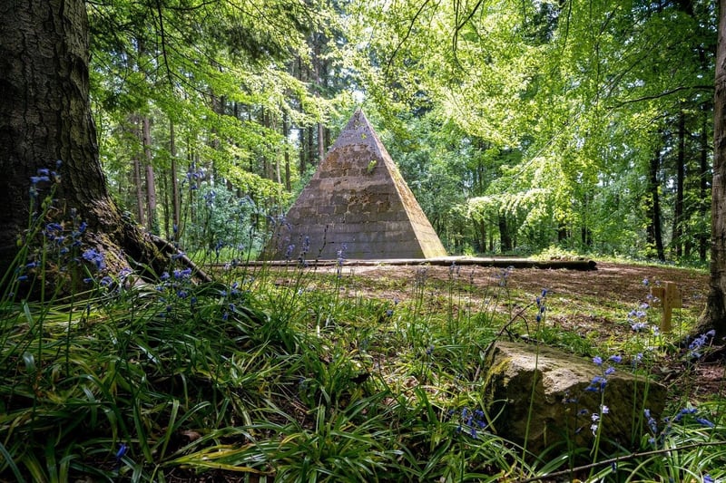 This pyramid was erected by Lord Garvagh after having been on the Grand Tour of Egypt, and is located on high ground in a bluebell wood, west of the car park at Ballinameen Bridge, at the south end of Garvagh.
It was intended as the burial vault for Lord Garvagh but it was never used and the entrance has now been bricked up. The pyramid is 18 feet square at the base and is erected on a raised platform 21 feet square; it is 21 feet high and built of freestone blocks.