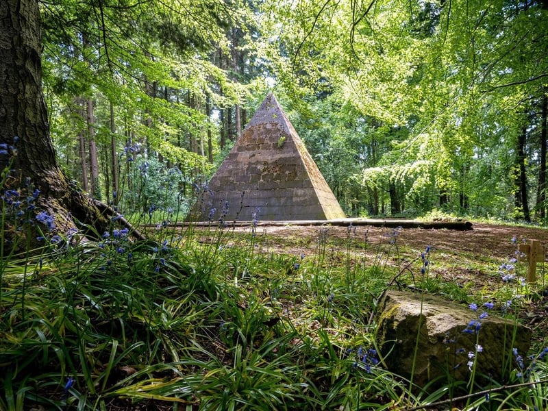 This pyramid was erected by Lord Garvagh after having been on the Grand Tour of Egypt, and is located on high ground in a bluebell wood, west of the car park at Ballinameen Bridge, at the south end of Garvagh.
It was intended as the burial vault for Lord Garvagh but it was never used and the entrance has now been bricked up. The pyramid is 18 feet square at the base and is erected on a raised platform 21 feet square; it is 21 feet high and built of freestone blocks.