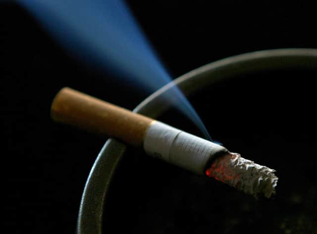 A cigarette burning on an ash tray.