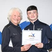 Tighearnan is pictured receiving his award certificate from Lady Mary Peters. (Pic: Contributed).