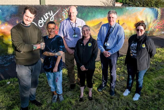 Pictured at the launch of the Doury Road mural in Ballymena are John Read, Housing Executive Good Relations Officer; Roy McClean, Housing Executive Mid and East Antrim Area Manager; mural artists Carly Wright and Sam McAleese; Jan Roscoe, Community Coordinator, Doury Road Development Group, and Roni Browne, Finance and Admin officer, Doury Road Development Group. Photo: NI Housing Executive