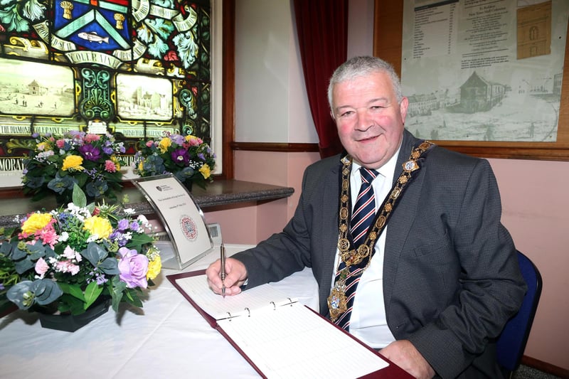 The Mayor of Causeway Coast and Glens, Cllr Ivor Wallace, signs the book of congratulations for King Charles at Coleraine Town Hall .