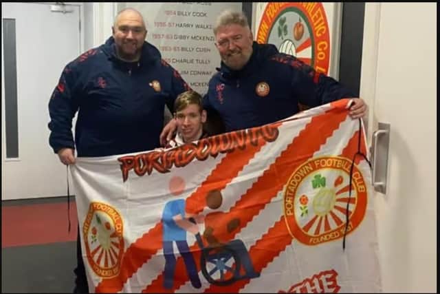 Kingston Bryars showing off his 'Wheeling down the Brownstown Road' banner to Portadown manager Niall Currie (right) and assistant boss Clifford Adams. (Photo by Kingston Bryars)