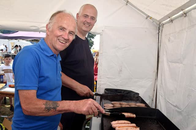 Alan Milligan, left, and Rev Gary Galway, Drumcree Parish Church rector, keeping the food stall at the Drumcree Family Fun Day and Vintage Rally well stocked with burgers and sausages. PT23-229.