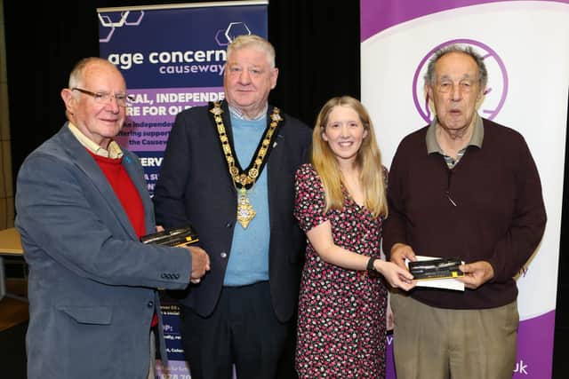 Mayor of Causeway Coast and Glens, Councillor Steven Callaghan and Museum Officer Jamie Austin presenting a gift to Tommy McDonald and Nelson McGonagle. Credit Causeway Coast and Glens Council