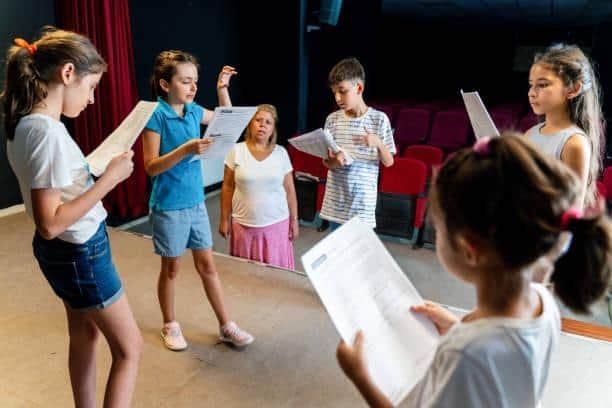 Group of children enjoying drama club rehearsal. Credit: Getty Images