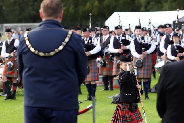 Mayor of Antrim and Newtownabbey, Councillor Mark Cooper, receives the salute from this young band member.