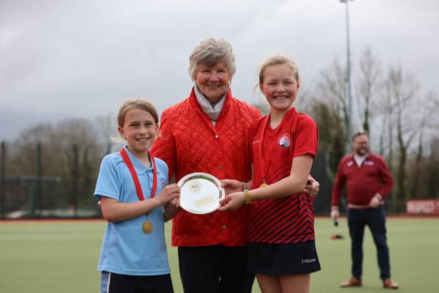 Joan McCloy (centre), former President of the Irish Hockey Association with pupils from Girls’ Competition Plate winning schools, Abbey Primary School, Newtownards and Moira Primary School. Image credit: The Front Row Union Sports.