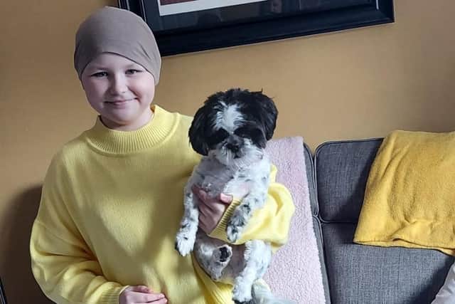 Brave Poppy Ogle in her favourite yellow jumper, with puppy Pyper.