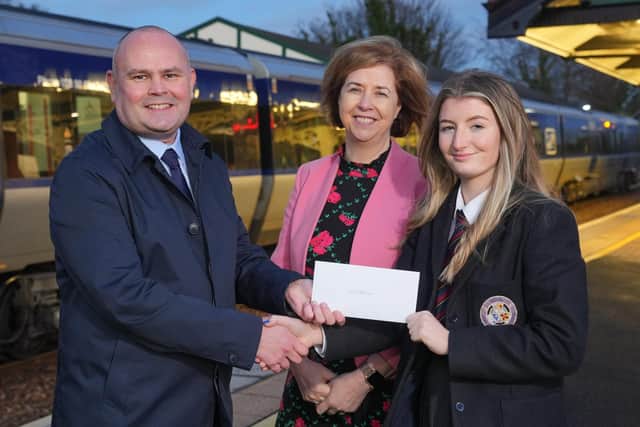 Molly is presented with iLink travel tickets by Clive Watson, Translink asst. route manager, included is Hilary Woods, principal of BRA. Pic: Aaron McCracken