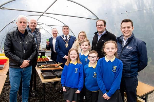 Then-Mayor of East and Mid Antrim Noel Williams poses for a photo in the polytunnel with Sunnylands Primary School pupils after officially opening Sunnylands Primary School allotments in Carrickfergus. Also pictured are staff from the Housing Executive and Idverde along with local elected representatives. Photo: NI Housing Executive