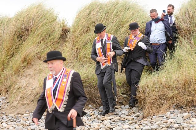 Orange men make their way to the beach.