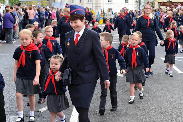 Brenda Johnston with St Columba's Penguins during the Commonwealth Day Youth Parade in 2015. Brenda is giving some young boys and girls a helping hand at the parade in Portadown. INPT24-232.