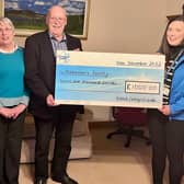 Ronnie, together with his wife and daughter, present a cheque for £1000 to Alzheimer’s Society