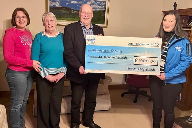 Ronnie, together with his wife and daughter, present a cheque for £1000 to Alzheimer’s Society