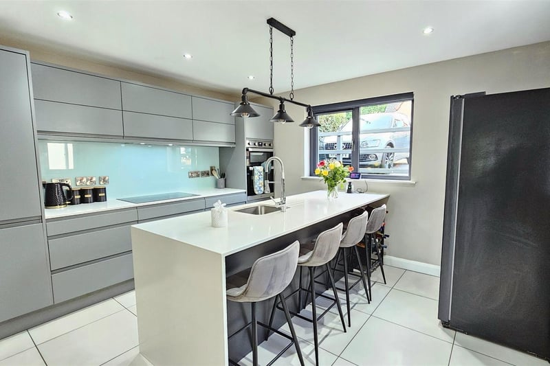Kitchen with double glazed window to front aspect, excellent range of contemporary high and low level units with granite worktops and glass upstands, integrated oven and ceramic hob with concealed extractor over.  There is also a breakfast bar incorporating a granite worktop and right angled granite gable, inset stainless steel sink with mixer tap over, and tiled flooring.