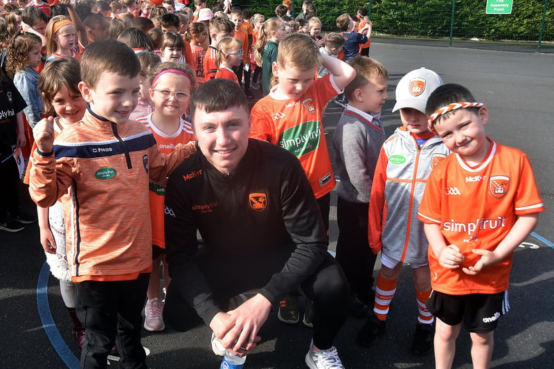 Former St John The Baptist Primary School pupil and Armagh GAA squad member, Oisin Conaty is surrounded by pupils at the school's Armagh Day. PT19-202.
