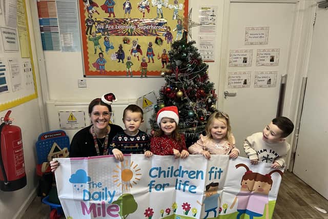 L to R: Pre-school Leader, Leah Emberson, with Kade, Molly, Amelia-Grace, and Tom get ready for the Daily Mile Santa Run