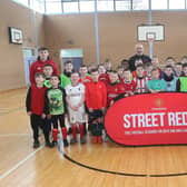 Some of tbe younger age group pictured with Manchester United Foundation's Stephen Parkhouse and Foundation coaches at the Easter tournament in Oakgrove College.