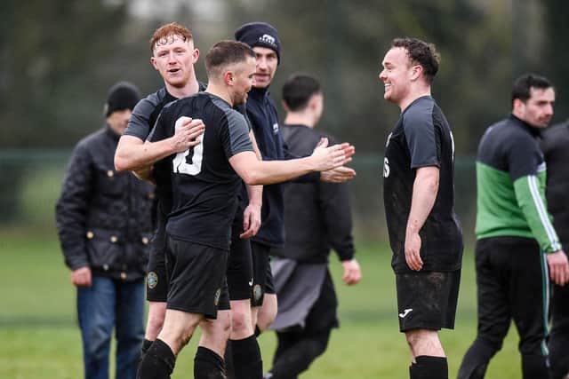 Newry Celtic players Ryan Fearon and Ronan McGrath congratulate match winner and double goal scorer Keith Johnston (centre).