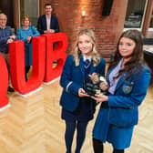 Katie O'Reilly of Rathmore Grammar (left) and Emma McNally of St Mary's Grammar (right) are presented with the 2023 NI Schools' Business Challenge winner's trophy as joint champions by event organisers (L-R) Laura Jackson, BDO NI Partner and Honorary Professor at Queen's Management School, Professor Ciaran Connolly of Queen's Management School, Jill Armer, Education Manager for Business Studies at CCEA and Billy Moore, Financial Director at Henderson Group.Pic: Brian Thompson
