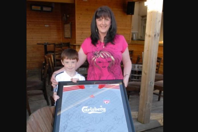 Marc Murray with mum Rosie and the signed Liverpool shirt they got at the PAC auction in the Olderfleet Bar in 2009.