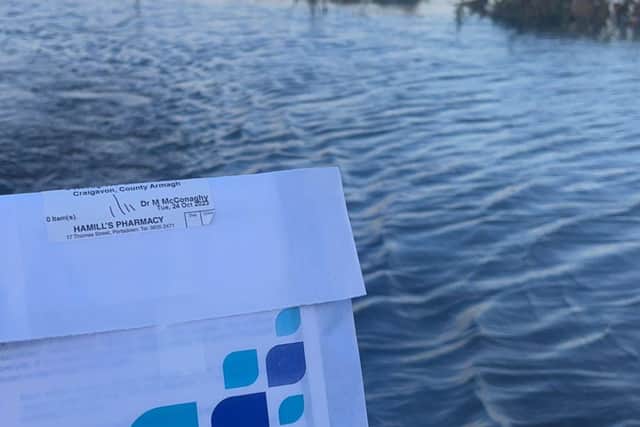 Katie Girvan from Hamill's Pharmacy in Portadown hitched a lift with boatman Barry McCann to deliver urgent medication to an elderly customer during floods in the Co Armagh town yesterday.