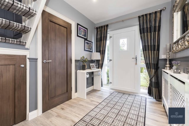 The bright entrance hall has a UPVC entrance door with glazed panels to either side, wood effect laminate flooring and wall panelling to walls. There is also a cloakroom and storage closet under the stairs.