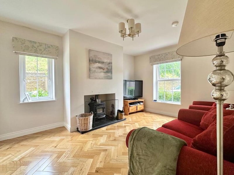 Living room with feature wood burning stove and herringbone parquet solid wood floor.