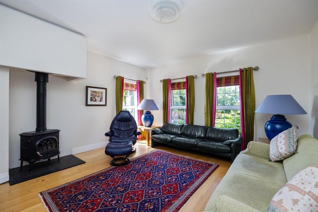 Family room with dual aspect windows and cast iron, wood burning stove on slate hearth.