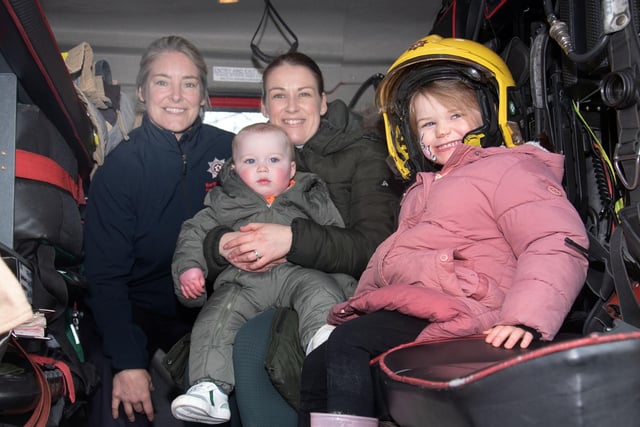 Enjoying the chance to get inside a real fire engine are Jolene Smyth and her childrem, Enda (1) and Eirinn and firefighter El Fegan, left. PT13-267.