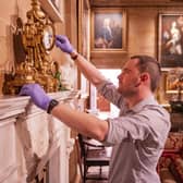 The State Entrance, showing David Orr (Castle and Collections Manager) examining a bronze mantel clock (mid-late 19th Century) © Historic Royal Palaces