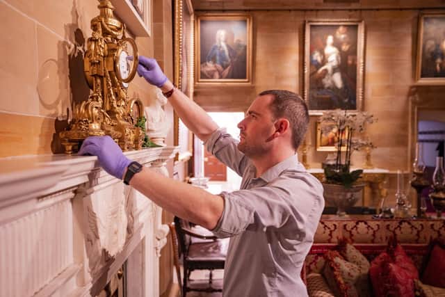 The State Entrance, showing David Orr (Castle and Collections Manager) examining a bronze mantel clock (mid-late 19th Century) © Historic Royal Palaces