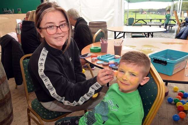 Face painter Katie McEvoy works her magic on the face of Kenzie (6). LM35-247.
