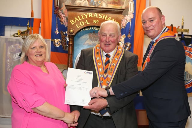 Mrs Linda O’Reilly receiving her certificate from the Grand Master and the Worshipful Master of Ballyrashane LOL 431