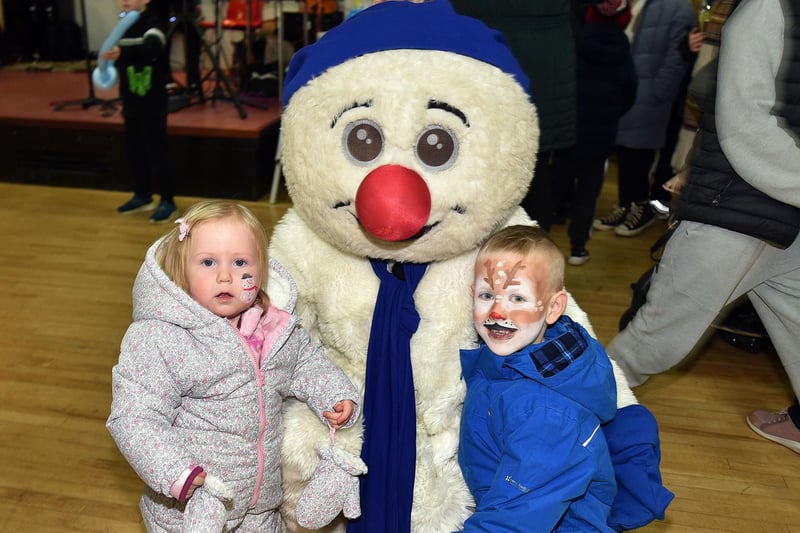 Frosty The Snowman was a popular attraction at the Mourneview estate Christmas lights switch on and party and he is pictured here with Annie Burns (1) and big brother Archie (6). LM50-255.