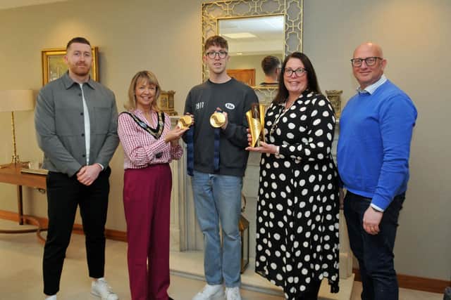 Daniel Wiffen shows his gold medals from the World Championships in Doha to ABC Lord Mayor, Alderman Margaret Tinsley. Included are Ben Wiffen and parents, Jonathan and Rachel Wiffen. Photo: Armagh City, Banbridge & Craigavon Borough Council