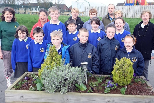 Knockmore Primary School pupils pictured with members the National Trust planting flower beds at the School when the National Trust Paid a visit in 2012