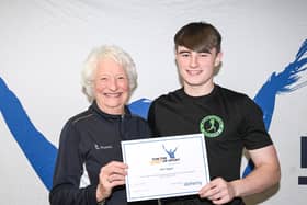 Mary Peters Trust award winner and athletics competitor Zak Taggart from Coleraine is pictured receiving his award from Lady Mary Peters. Credit Mary Peters Trust