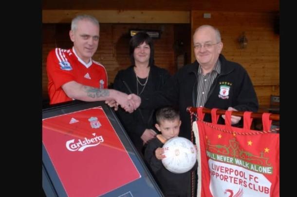 Jim Elliott (right) of the Olderfleet Liverpool Supporters' Club congratulating Owen, Alan and Debbie Maltman on their autographed items they got at the Parents Against Cancer auction in the Olderfleet Bar in 2009.