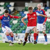 Linfield’s Jordan Stewart with Larne’s Dylan Sloan during Monday evening's match at Windsor Park. Picture: Jonathan Porter / Press Eye