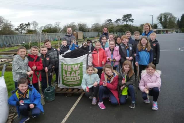 Pupils and staff at St Francis PS in Lurgan with Sharon McMaster of organics firm Natural World Products (NWP). The firm will begin a collaborative working relationship to create a sustainable allotment programme with pupils at the school.
