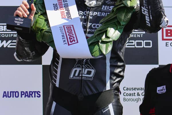 Michael Dunlop smiles to the crowds on to the podium after being declared the Superbike Race Winner amid a controversial penalty incident