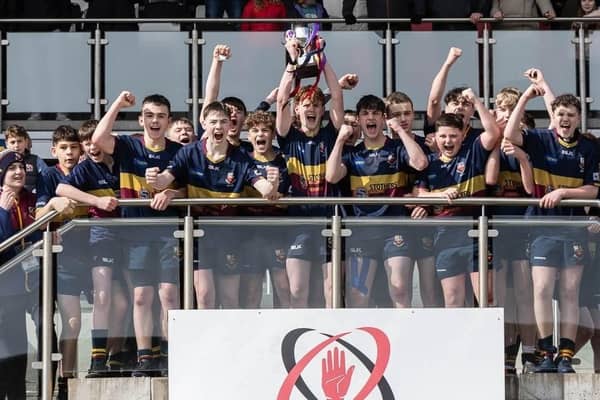 Bann U14 captain Ryan Johnston raises the Ulster Cup as the rest of his team celebrate their win at the Kingspan Stadium.