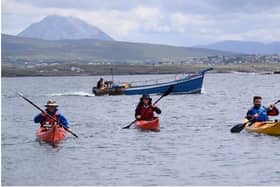 John Hubbocks, Tessa Fleming and Irial Ó Ceallaigh approach Gabhla Island with fishing boat behind them in episode one. The kaykers will make their way around the coast to Ballycastle and Rathlin. Credit Macha Media