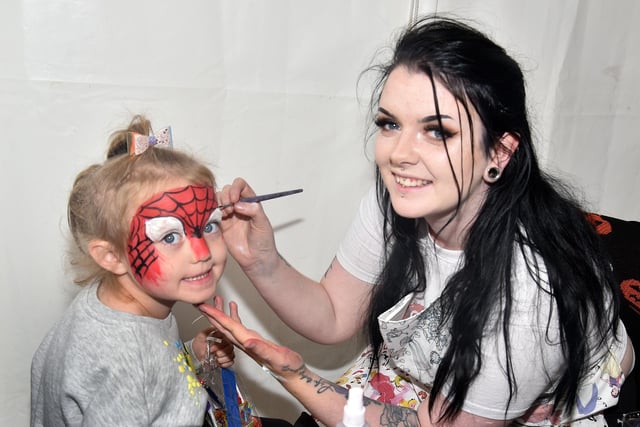 Lacey McCann (5) has her face painted by Charlotte Lewsley of Glitter and Gore at the Portadown Credit Union stand at Country Comes To Town. PT41-206.